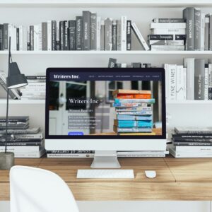 Modern workspace with books and computer for writers and creatives.