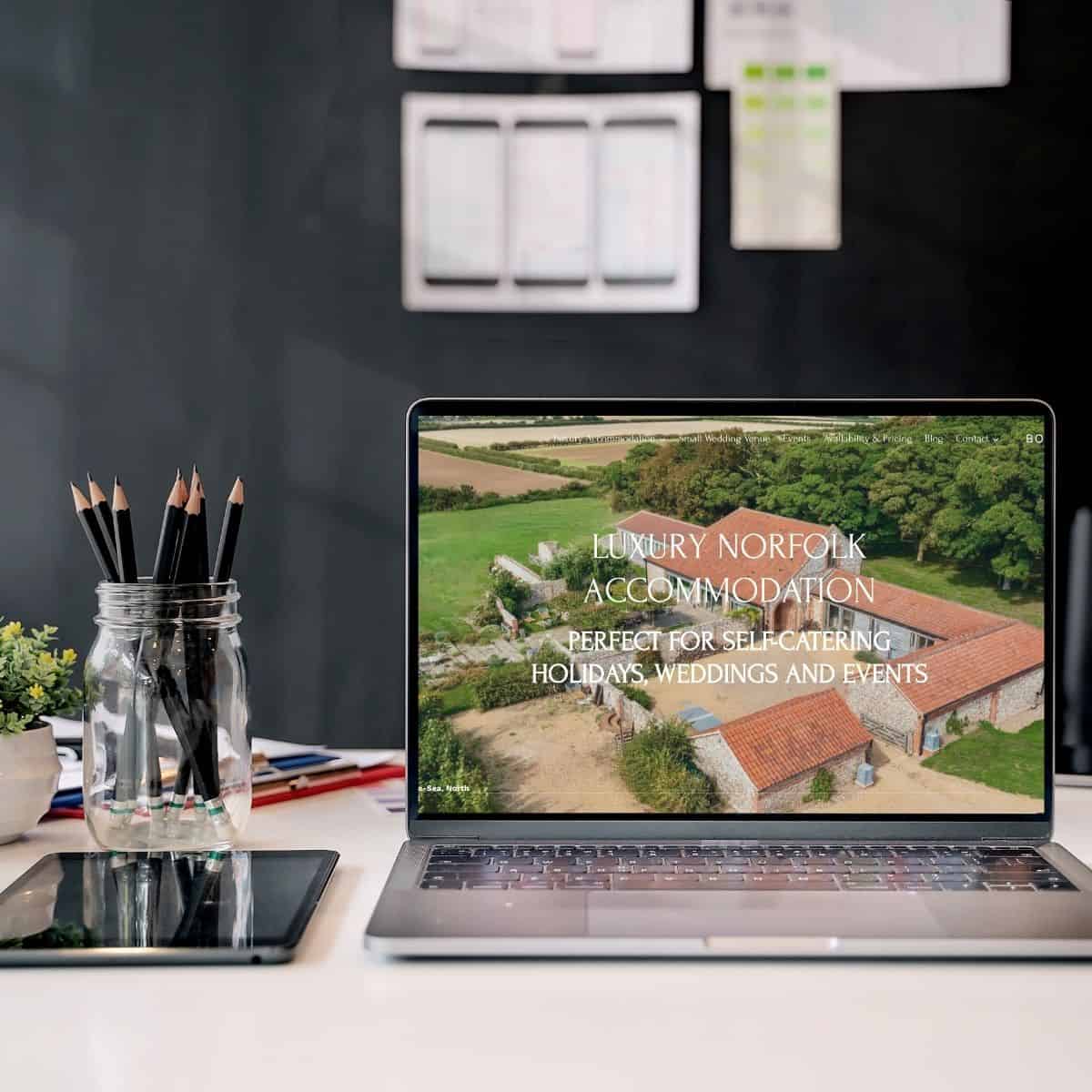 Luxury Norfolk accommodation on laptop screen, perfect for self-catering, holidays, weddings, events.